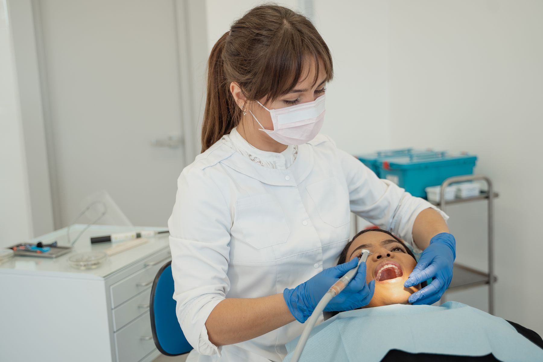 A dentist treating a patient in a bright operatory