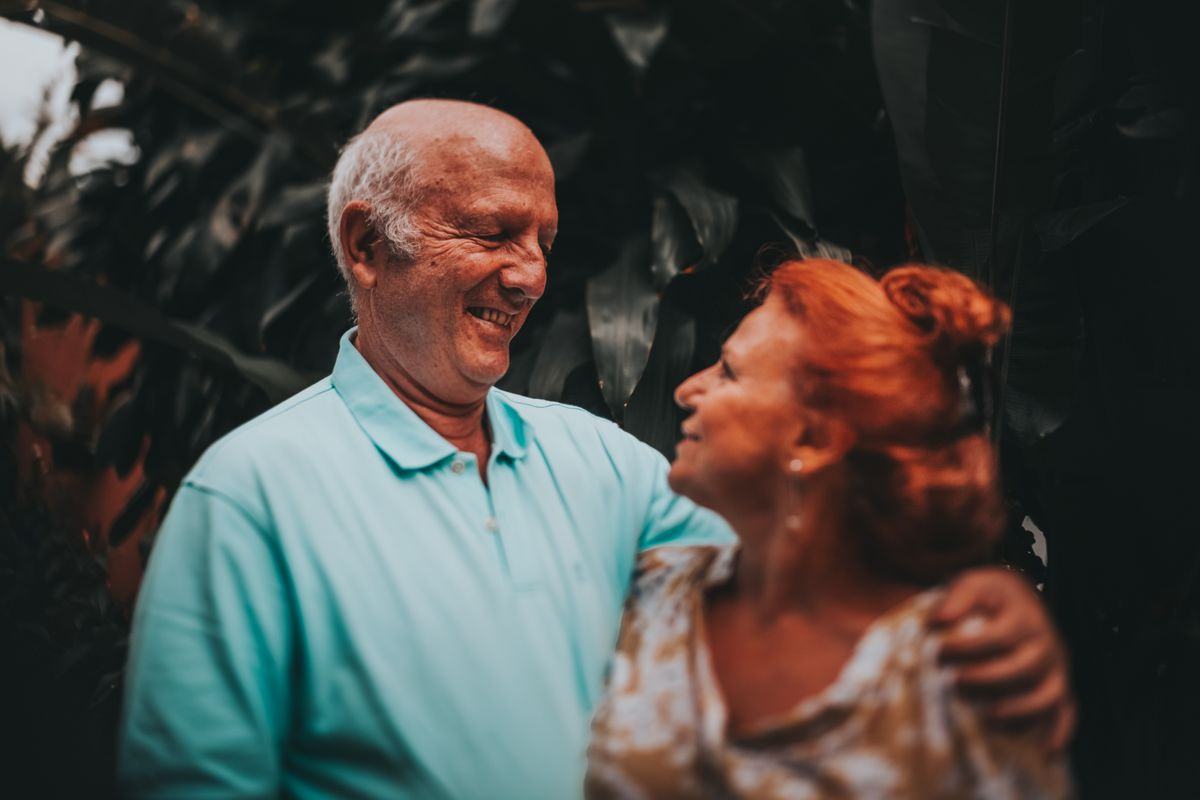 A retired couple laughing together outdoors